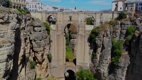 drone shot flying in under the bridge in ronda, spain