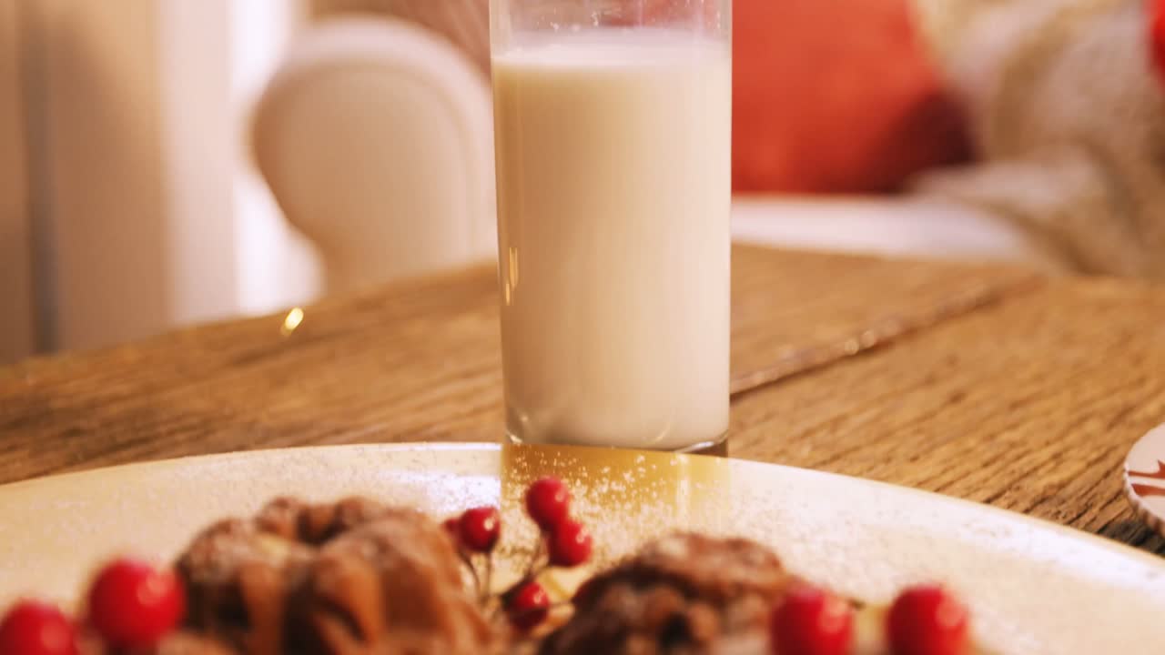 Weihnachtsplätzchen auf einem Teller mit einem Glas Milch