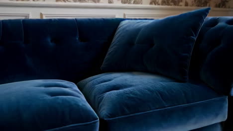 stylish living room with blue velvet sofa and floral wallpaper