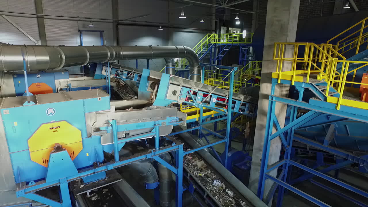 residuos de la planta de reciclaje en transportadores en movimiento, interior de la fábrica de reciclaje, disparo de drones en cámara lenta