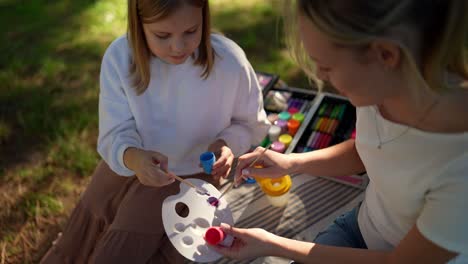 mother and daughter painting outdoors