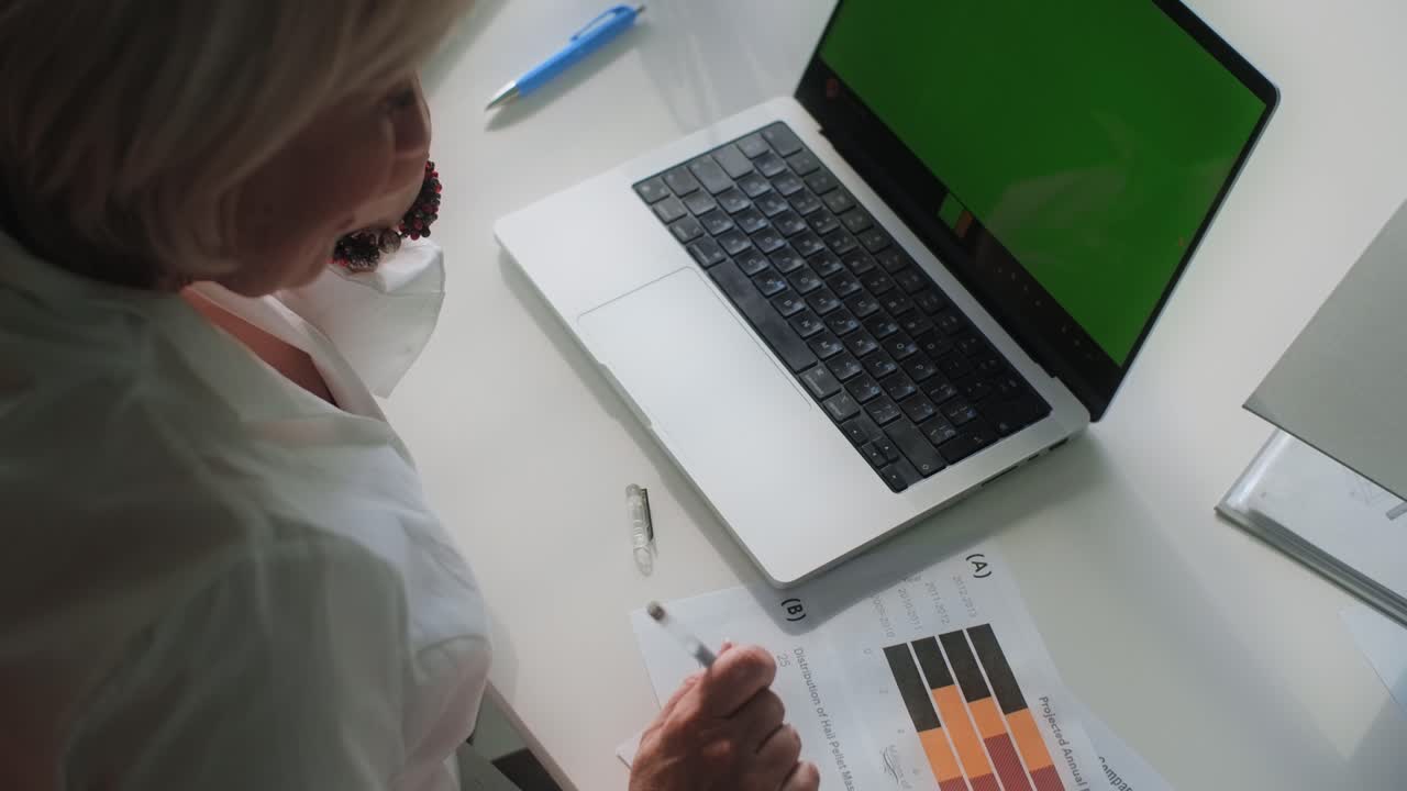 Woman working on laptop and documents in the office