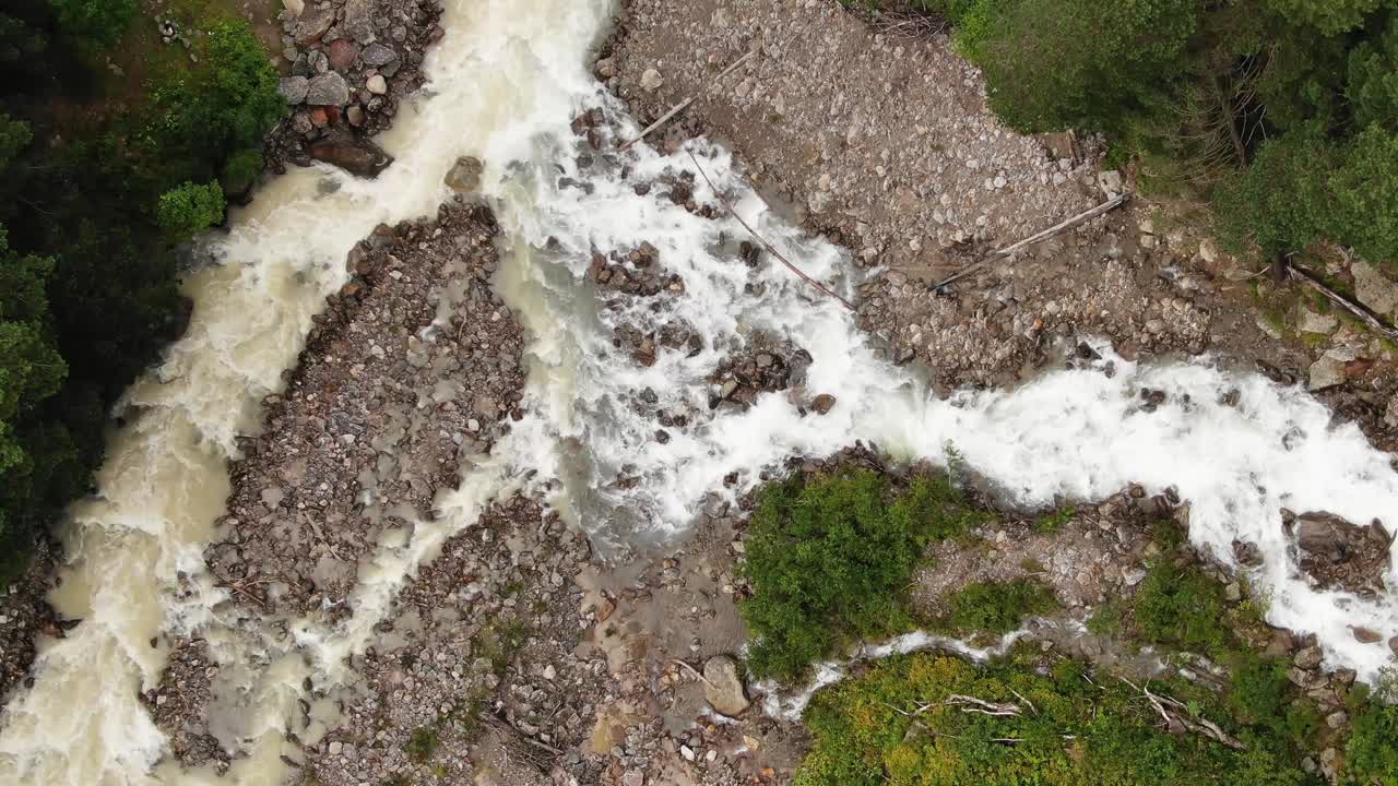 un río estrecho con corrientes de agua rápida corre hacia abajo entre las rocas
