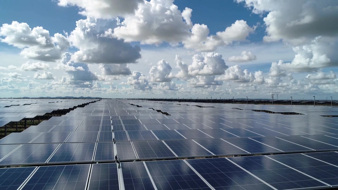 Startende fremadgående kamerabevægelse, dronekamera overvåger solcellepaneler, der reflekterer skyer.