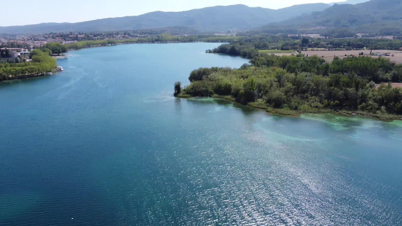 Riprese aeree con drone in rotazione di un famoso e bellissimo lago naturale con acque blu e turchesi in Catalogna, Spagna