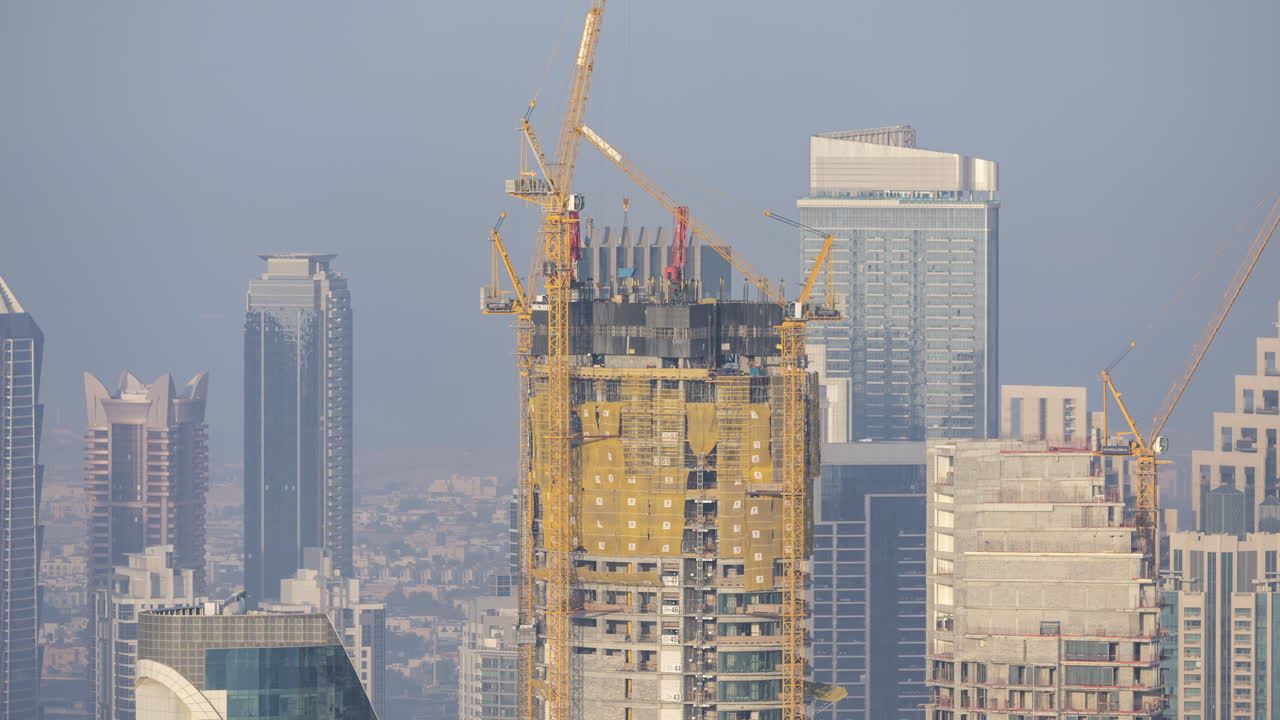 Grattacielo in costruzione con gru nello skyline cittadino