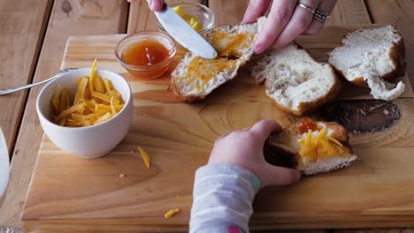 Mom-preparing-bread-with-jam---cheese-for-hungry-toddlers