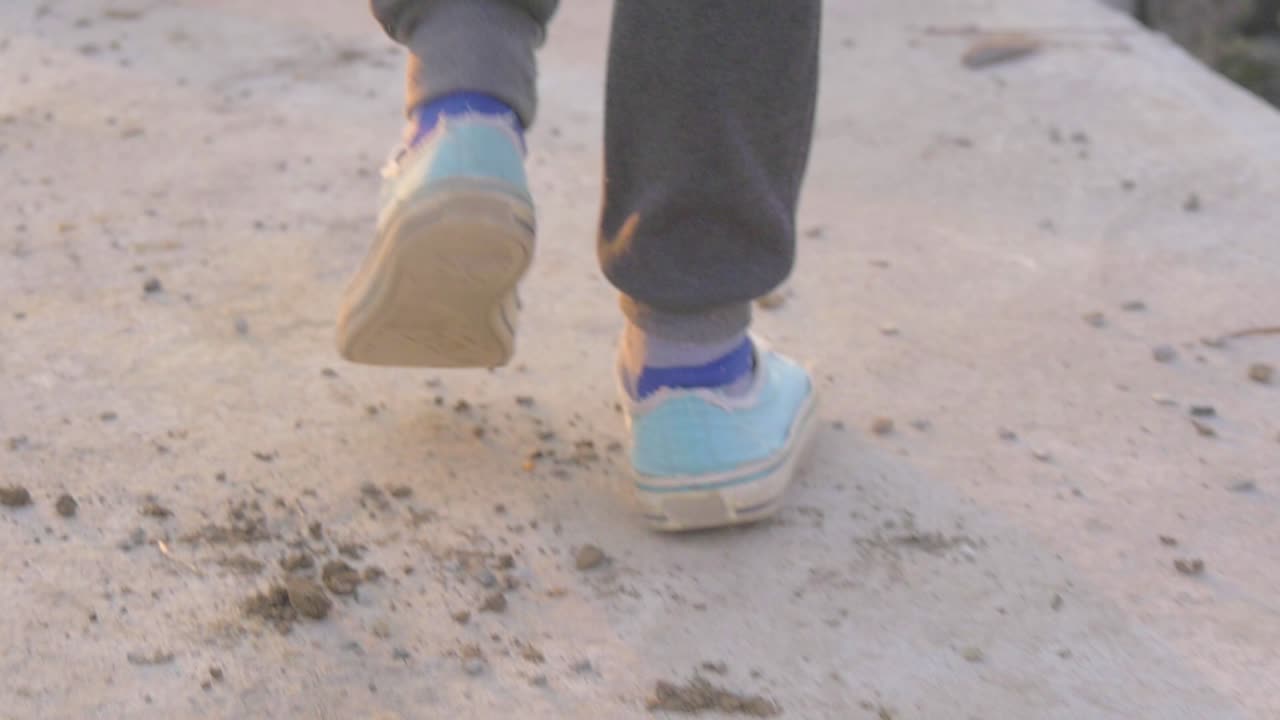 una chica caminando por un camino en cámara lenta con una agradable luz cinematográfica que golpea la escena desde un lado