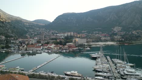 Drone-dolley-shot-of-luxurious-yachts-moored-at-the-blue-Adriatic-sea-in-Kotor-between-the-high-mountains