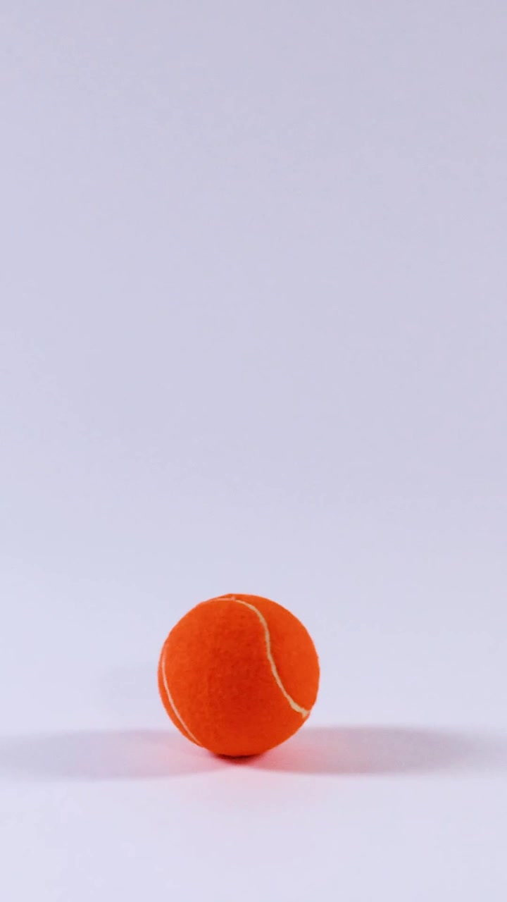 Oranssi tennispallo vierii valkoisella pinnalla