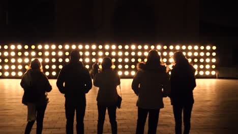 people with their backs against the light of some led bulbs