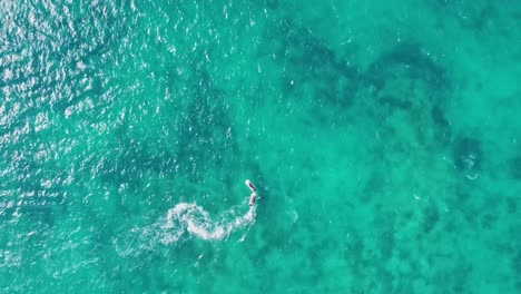 AERIAL---Boat-speeding-through-the-beautiful-turquoise-waters-of-Cancun,-Mexico