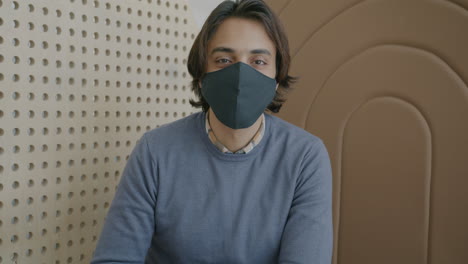 man wearing mask in modern interior