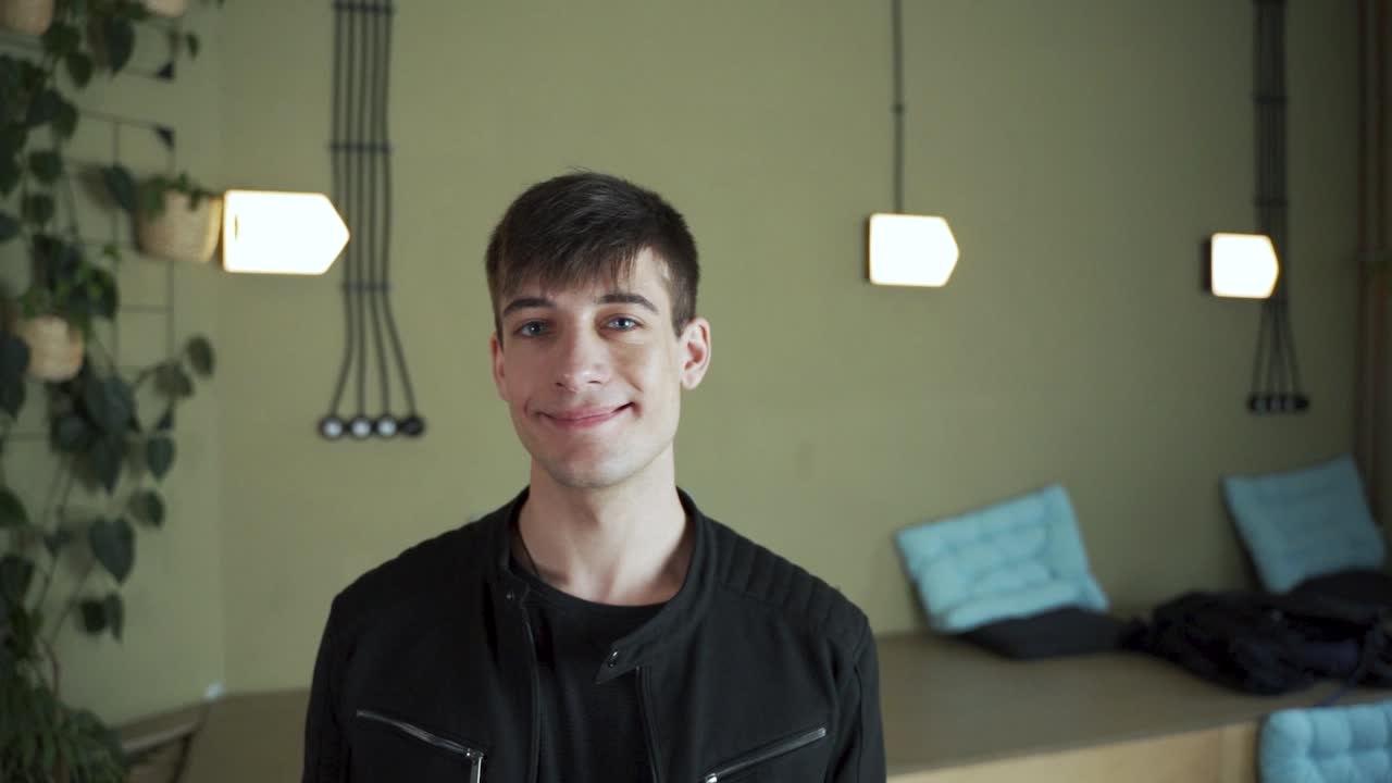 cara de joven estudiante europeo de pelo oscuro positivo mirando a la cámara diciendo sí, de acuerdo, hazlo sonriendo