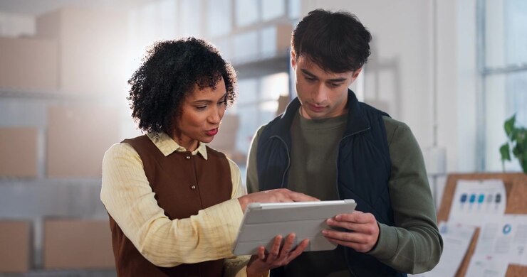 Two Colleagues Discussing Project Details on a Digital Tablet