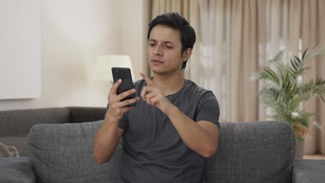 Indian-man-scrolling-through-phone