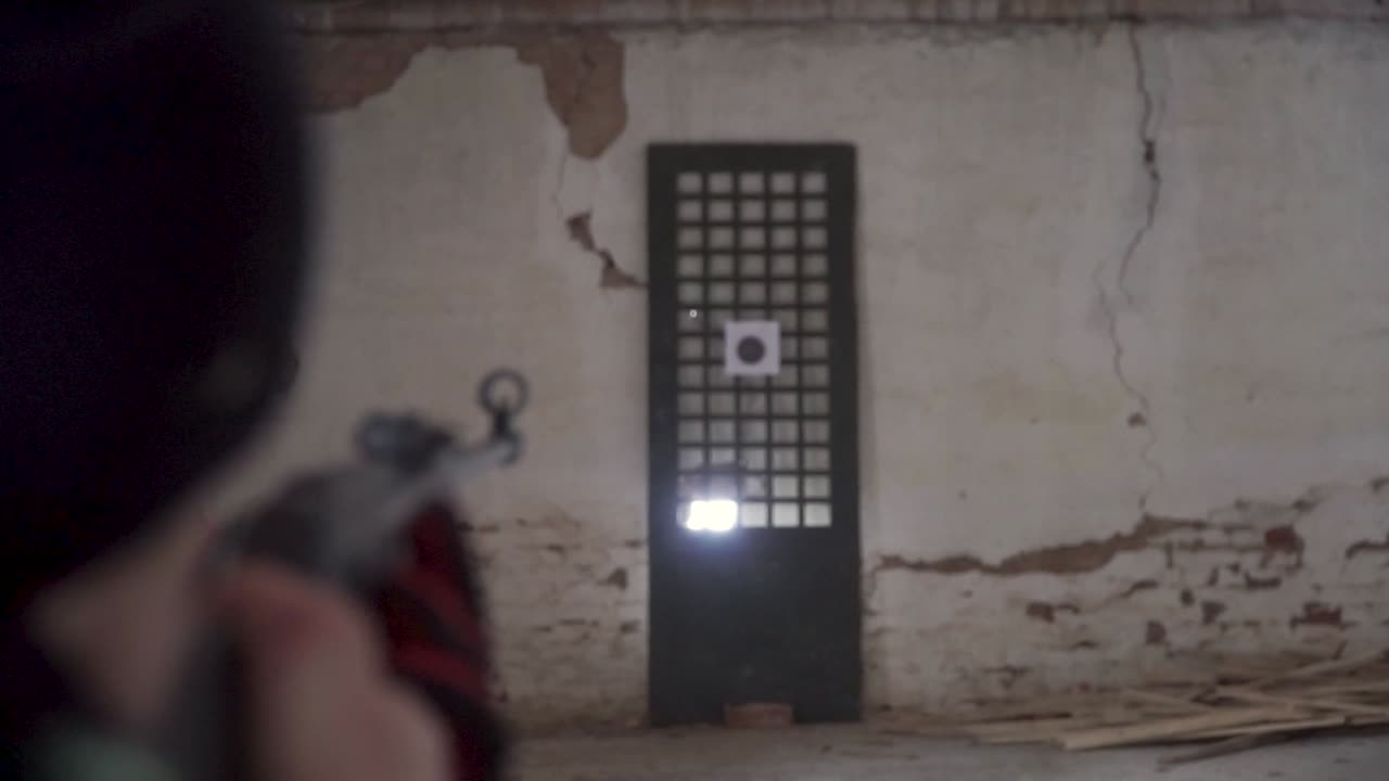 persona disparando al objetivo en el campo de tiro interior