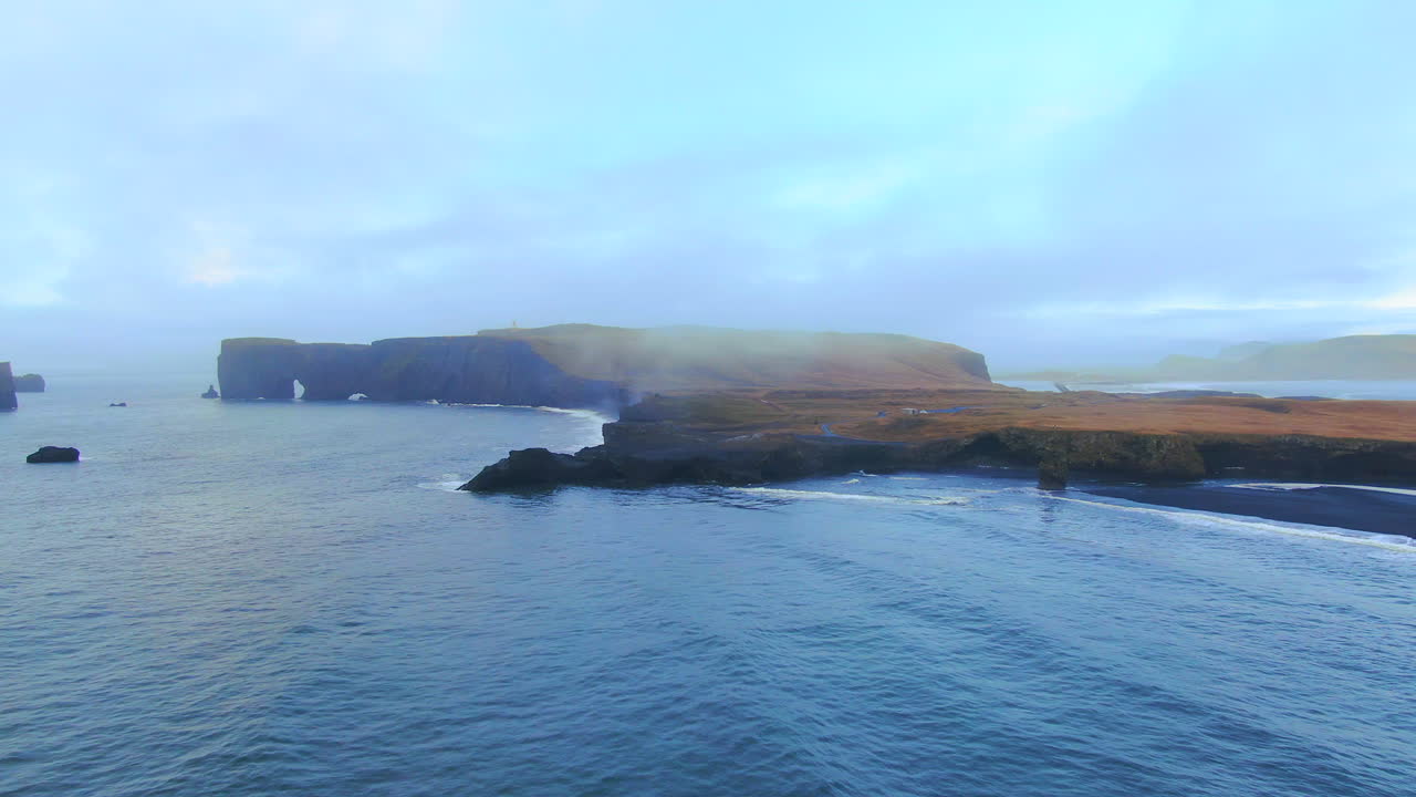 공중 영화 드론 왼쪽 놀라운 일출 초기 겨울 블랙 샌드 해변 사도 불과 얼음 바다  ⁇ 에 dyhrolaey 등대 reynisfjara 아이슬란드