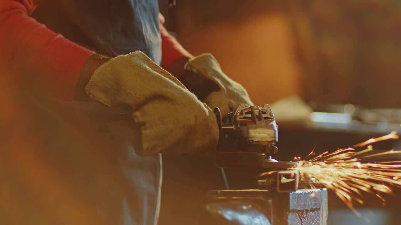 manos de herrero pulido billete de hierro con molinillo angular que produce chispas