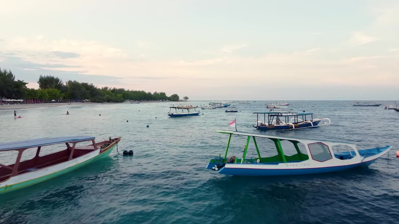 Drone flying low over numerous tourists boats floating on sea water surface. Aerial.
