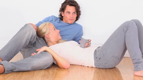 happy couple on the floor with a cup