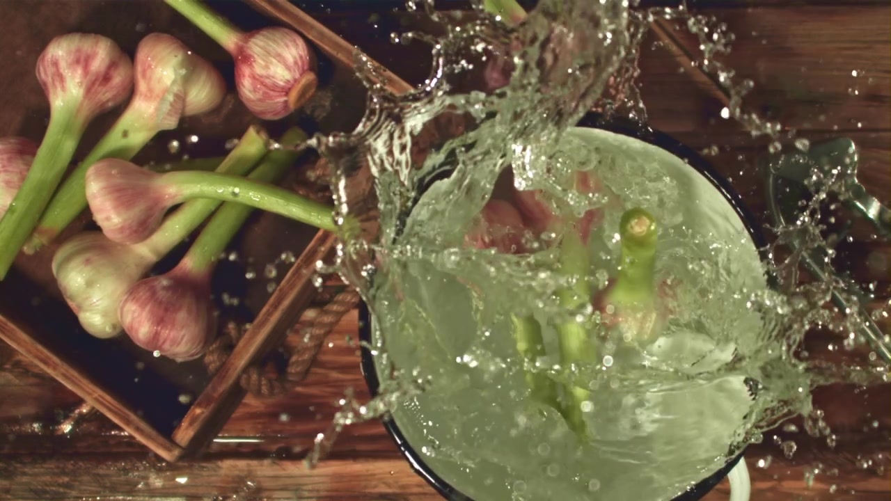 Teste d'aglio fresche che si tuffano nell'acqua in una pentola