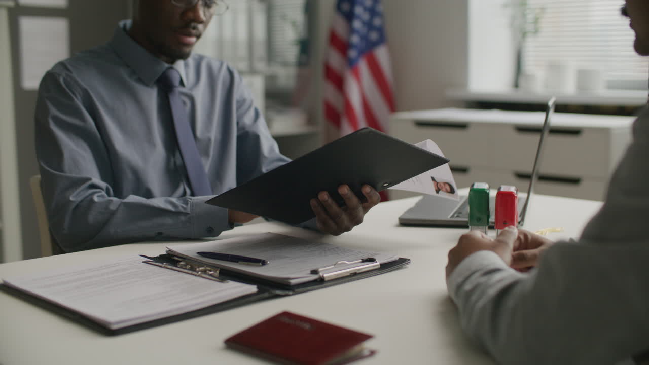 Consular Officer Reviewing Documents and Conducting Visa Interview at US Embassy