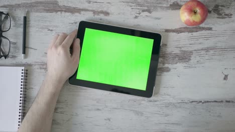 bebiendo café de cerca de la mano del hombre de negocios usando una tableta de pantalla verde.