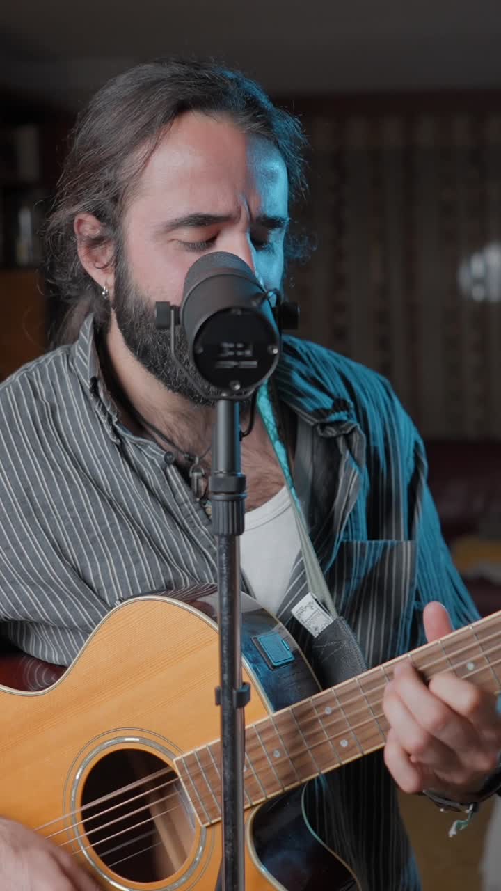 Musician passionately playing acoustic guitar and singing into a microphone