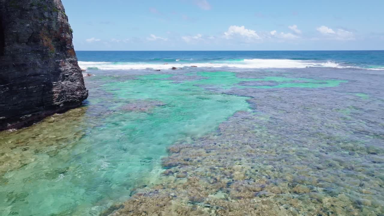 tomada aérea amplia que muestra las aguas claras del mar caribe con arrecifes de coral bajo el agua a lo largo de la costa rocosa de playa fronton, las galeras en samana