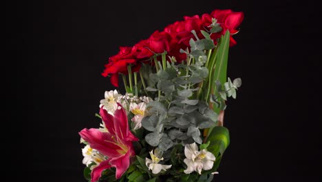 spinning flower arrangement orchids roses and lilies black background
