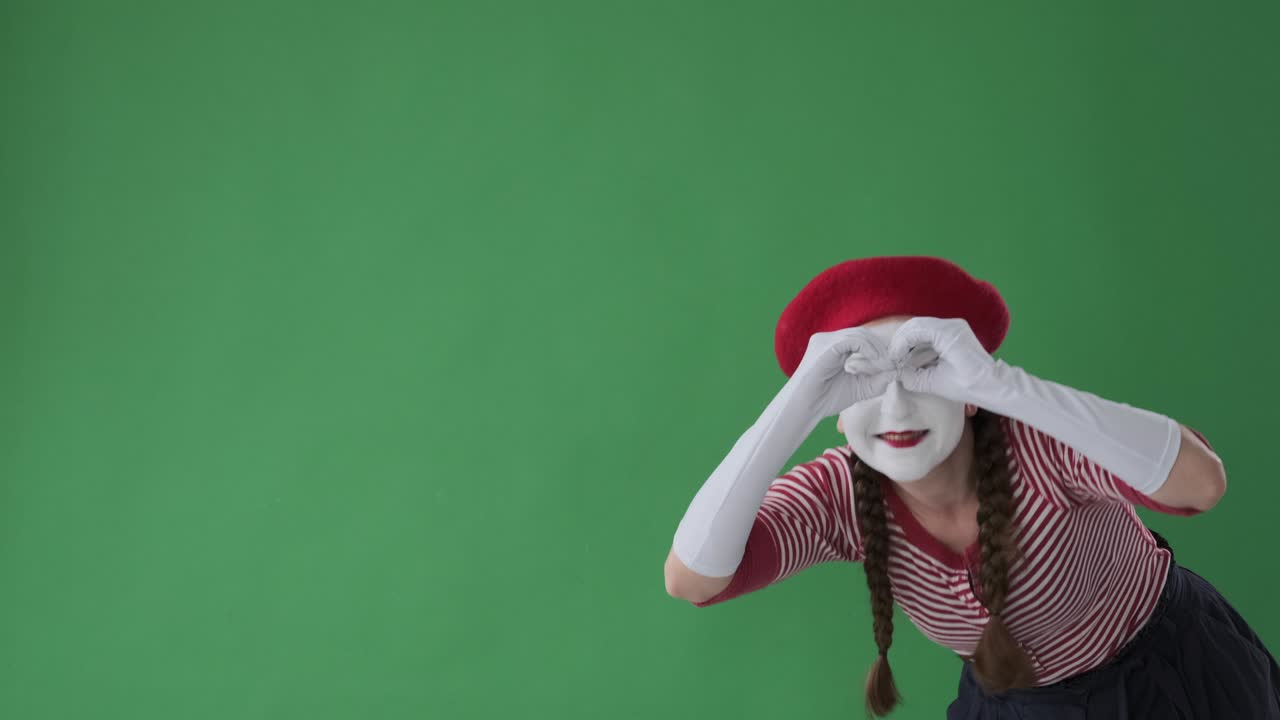 artista de mimo asombrado mirando algo interesante con binoculares hechos a mano