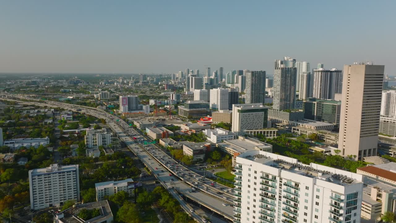 도시 구역의 공중 파노라마 뷰. 바쁜 다차선 고속도로에 기울어지고 밝은 낮은 태양이 긴 그림자를 던집니다. 마이애미, 미국