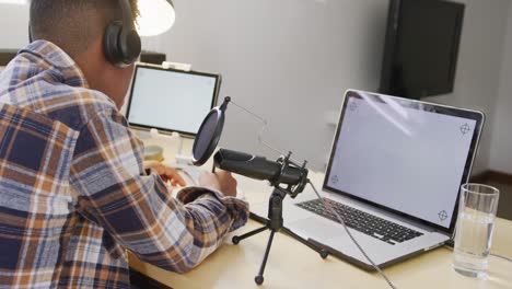 African-american-male-teenage-boy-recording-podcast-using-laptop-with-copy-space,-slow-motion