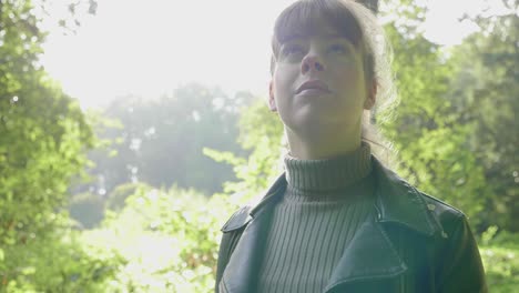 woman walks and admires surrounding nature in sunlight, close tracking