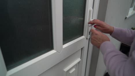 Retired-woman-leaves-house-and-locks-white-door