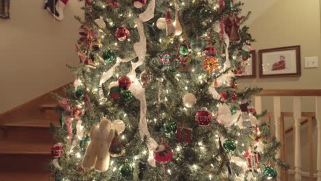 well decorated big indoor xmas tree near staircase