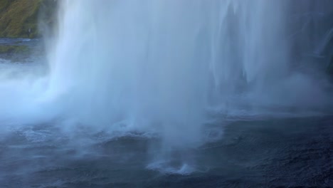 Powerful-plunge-waterfall-flow-pouring-water-on-river-surface,-close-up