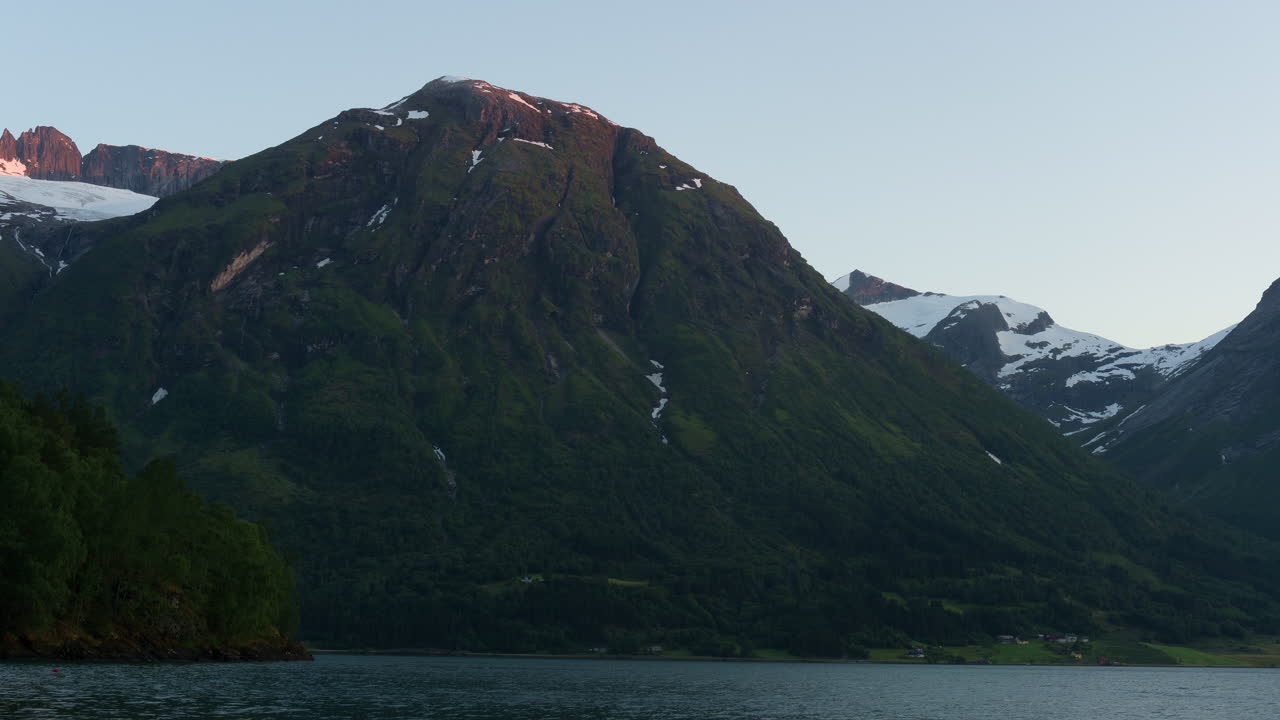 timelapse de la luz del atardecer golpeando montañas redondas por un fiordo noruego en el oeste de noruega