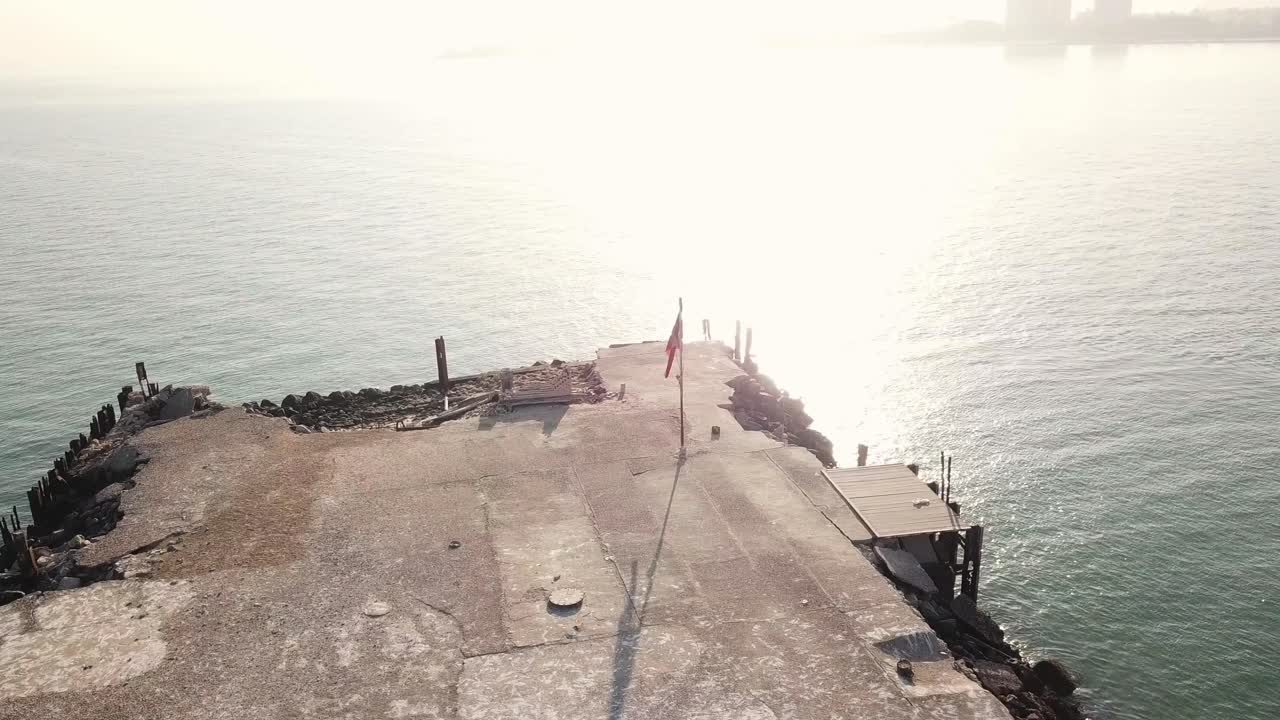Kuwaiti Flag on an Abandoned Man-made Island. Birds and Seagulls Flying it on a Peaceful Morning. Orbital Shot