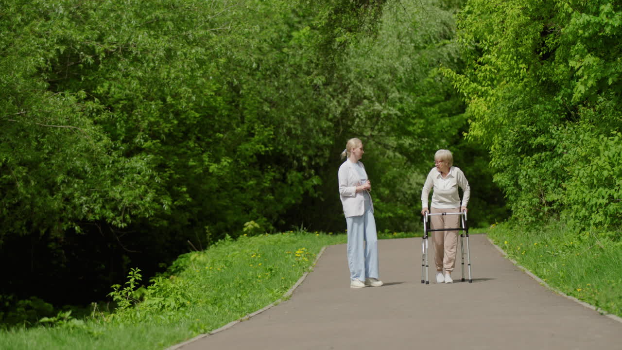 Ung kvinne og eldre kvinne går i en park