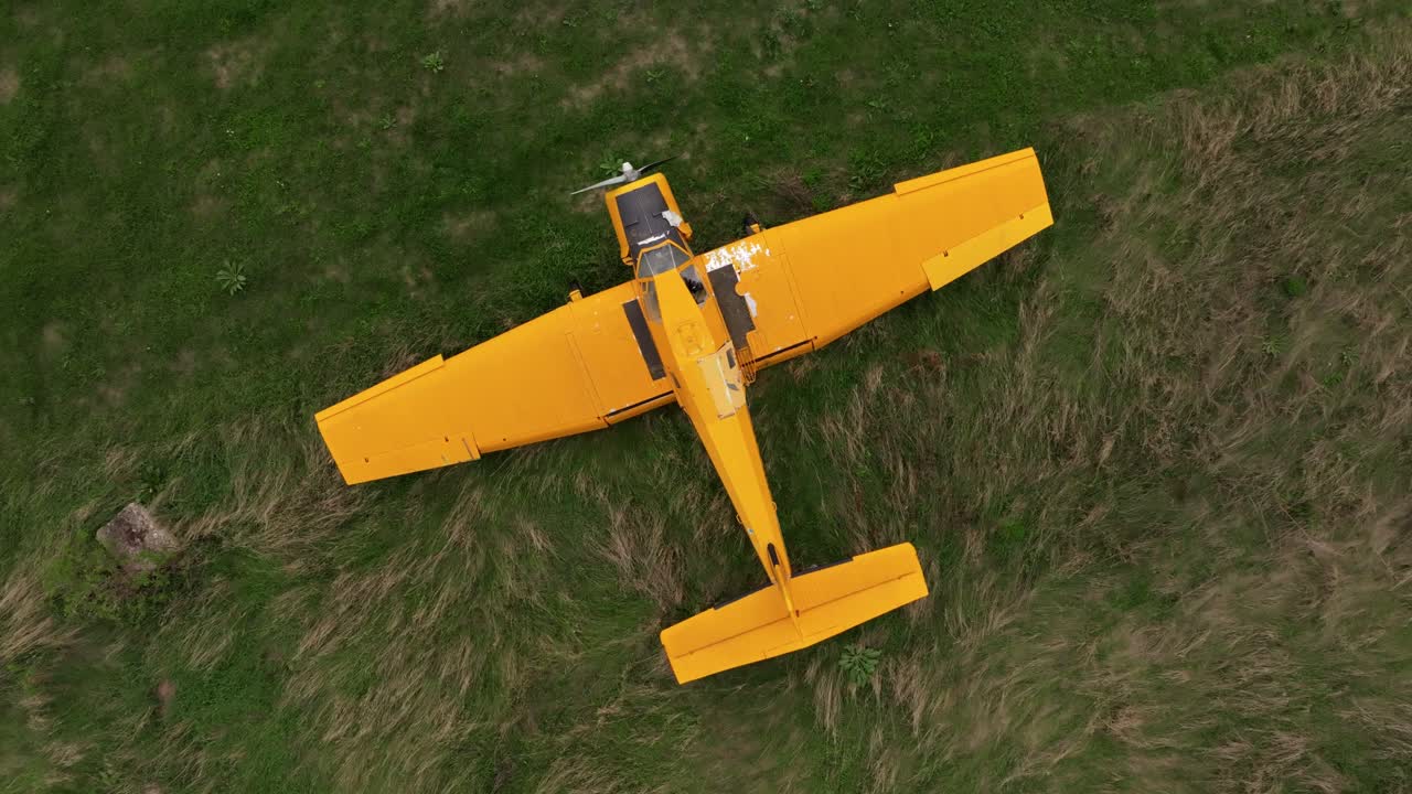 Immagine aerea di un aereo giallo logoro abbandonato in praterie selvagge