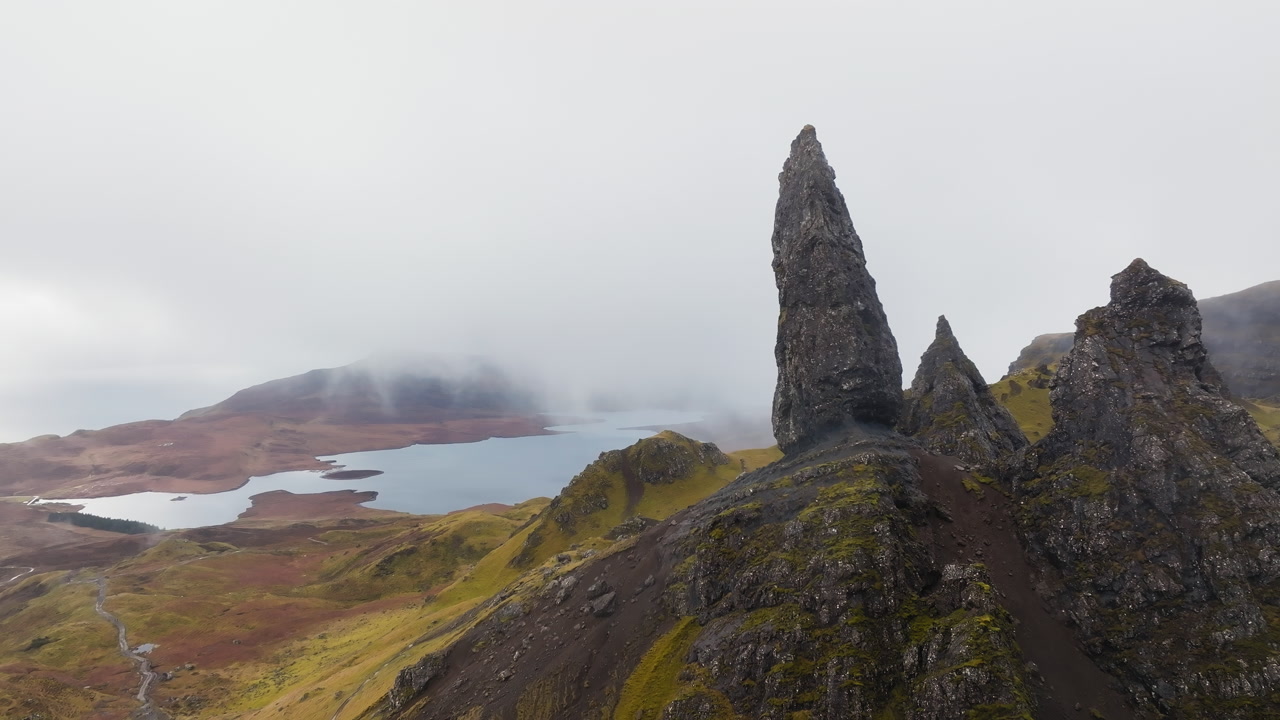 Aerial pullback shot reveals The Storr on the Isle of Skye in misty highland, Scotland
