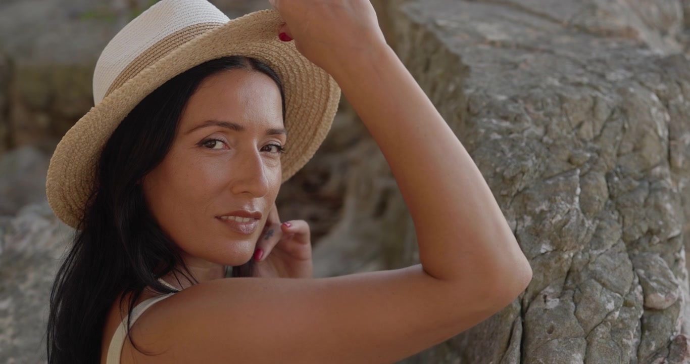 Ritratto di una giovane donna con cappello di paglia all'aperto