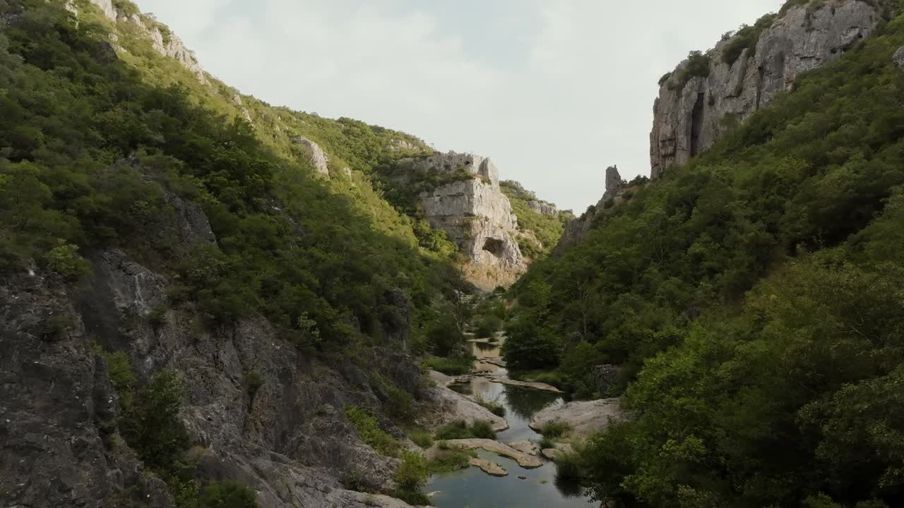 Filmato drone che riprende le scenografiche montagne rocciose in Scozia, Regno Unito, coperte da fitti alberi durante il giorno, mostrando la bellezza aspra del paesaggio naturale.