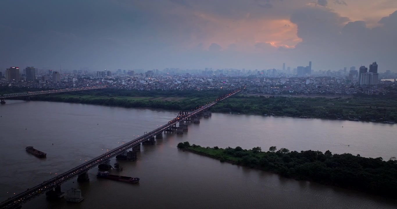 Ponte, navi in navigazione, paesaggio urbano di Hanoi, scena al tramonto, aerea.