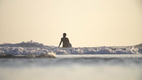 flachschuss eines surfers, der im meer spazieren geht