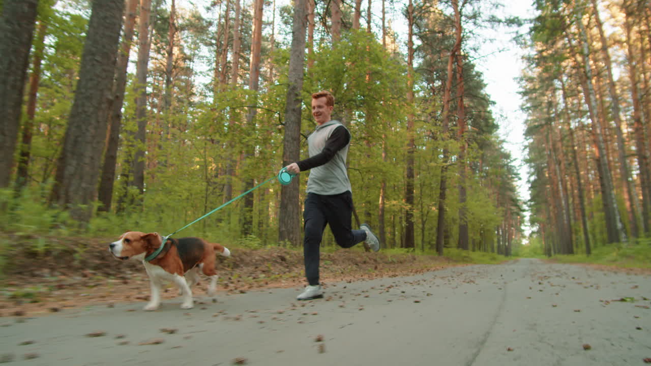 hombre corriendo con el perro en el bosque