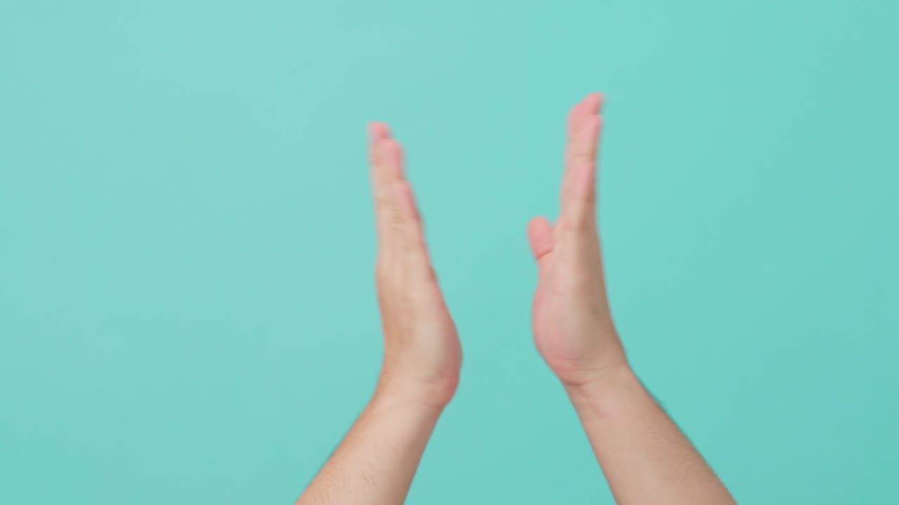 Close up shot of asian human hand raising with clapping hands. the man applauding to make a sound to bring people attention with feeling happy and joyful in isolate blue screen in background.