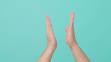 close up shot of asian human hand raising with clapping hands. the man applauding to make a sound to bring people attention with feeling happy and joyful in isolate blue screen in background.